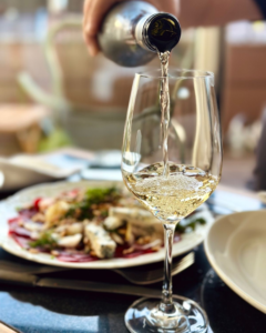 Ποτήρι λευκό κρασί που σερβίρεται σε τραπέζι με θαλασσινά